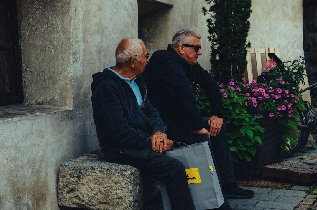 Senior couple sitting at a kitchen table looking at a laptop